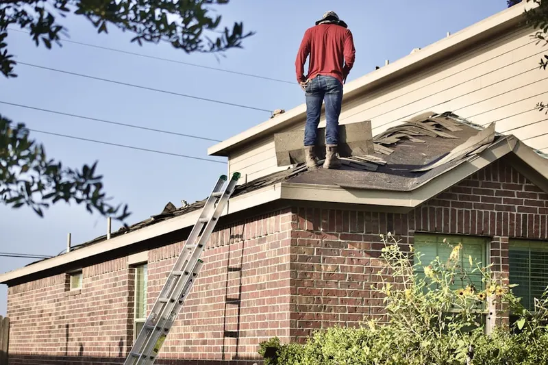 Professional roofer working on a residential roof in Bourne